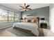Serene bedroom featuring a large window, ceiling fan, and neutral color palette, creating a relaxing atmosphere at 8961 Se 130Th Loop, Summerfield, FL 34491