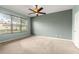 Carpeted bedroom with large window and ceiling fan at 8961 Se 130Th Loop, Summerfield, FL 34491