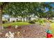 A well-maintained home featuring lush front yard landscaping with mature trees, plants, and a green lawn at 8961 Se 130Th Loop, Summerfield, FL 34491