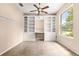 Well-lit home office featuring custom built-in shelving, desk and a ceiling fan at 8961 Se 130Th Loop, Summerfield, FL 34491
