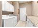 Laundry room featuring a washer and dryer, granite counters, and white cabinets at 8961 Se 130Th Loop, Summerfield, FL 34491