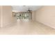 Large, open living space with tile flooring, neutral paint, ceiling fan, and access to kitchen and patio at 8961 Se 130Th Loop, Summerfield, FL 34491