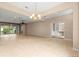 Spacious open living area featuring neutral tones, tile floors, ceiling fan, and views of the outdoors at 8961 Se 130Th Loop, Summerfield, FL 34491