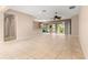 Open-concept living space with tile flooring, neutral walls, ceiling fan, and access to the screened lanai at 8961 Se 130Th Loop, Summerfield, FL 34491