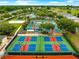 Aerial view of pickleball courts with red and blue playing surface surrounded by a tall fence and landscaping at 8961 Se 130Th Loop, Summerfield, FL 34491