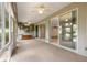 Spacious sunroom with multiple ceiling fans, large windows, and sliding glass doors at 8961 Se 130Th Loop, Summerfield, FL 34491