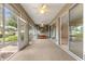 Long sunroom with large windows, multiple ceiling fans, and outdoor access at 8961 Se 130Th Loop, Summerfield, FL 34491