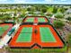 A view of multiple tennis courts with green playing surfaces and orange surrounding area at 8961 Se 130Th Loop, Summerfield, FL 34491