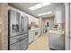 Kitchen with stainless steel appliances, white cabinets, and access to the laundry area at 9 Bahia Trace Loop, Ocala, FL 34472