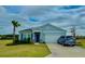 Inviting single-Gathering home featuring a two-car garage, well-maintained lawn, and blue trim at 9253 Sw 58Th Cir, Ocala, FL 34476