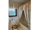 Bathroom featuring toilet and tub with curtain, and window with blinds at 9622 Se 71St Ct, Ocala, FL 34472