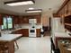 Kitchen with tiled countertops, white appliances, and wooden cabinetry at 9622 Se 71St Ct, Ocala, FL 34472