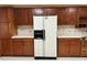 Traditional kitchen featuring white refrigerator, wooden cabinets and tiled countertops at 9622 Se 71St Ct, Ocala, FL 34472