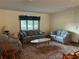 Living room with floral sofas, a coffee table, a window with blinds, and carpeted floor at 9622 Se 71St Ct, Ocala, FL 34472