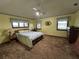 Cozy main bedroom features a ceiling fan, a floral bedspread, and three windows at 9622 Se 71St Ct, Ocala, FL 34472