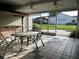 Enclosed outdoor patio with tile floor, metal table and chairs, and view of backyard at 9622 Se 71St Ct, Ocala, FL 34472