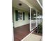 Cozy front porch with painted wood floors and white railing at 9622 Se 71St Ct, Ocala, FL 34472