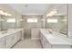 Bathroom featuring double sinks, white cabinets, and a large frameless glass shower at 9865 Sw 105Th Ct, Ocala, FL 34481