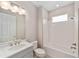 Modern bathroom features a shower-tub combo, white subway tile, and white vanity with stylish lighting at 9865 Sw 105Th Ct, Ocala, FL 34481