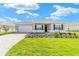 Charming one-story home with a lush green lawn, brick driveway, attached garage, and neatly landscaped flower beds at 9865 Sw 105Th Ct, Ocala, FL 34481