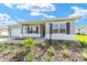 Attractive single-story home with a well-maintained lawn, brick driveway, and a cozy, covered front porch at 9865 Sw 105Th Ct, Ocala, FL 34481