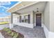 A welcoming covered front porch, brick entryway, and a view of the attached two-car garage at 9865 Sw 105Th Ct, Ocala, FL 34481