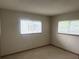 Neutral bedroom with carpeted floors, two windows, and a ceiling texture at 11248 Sw 76Th Ter, Ocala, FL 34476
