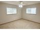 Comfortable bedroom with carpet, neutral walls, ceiling fan and two windows for natural light at 11248 Sw 76Th Ter, Ocala, FL 34476