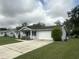 Features the home's garage, simple landscaping, and a well-maintained lawn at 11248 Sw 76Th Ter, Ocala, FL 34476