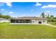 A spacious backyard featuring a screened-in patio, lush lawn, and mature trees for outdoor enjoyment at 12 Hemlock Radial Pass, Ocala, FL 34472