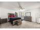 This spacious bedroom features a decorative bed frame, a ceiling fan, and neutral carpet at 12 Hemlock Radial Pass, Ocala, FL 34472
