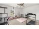 Bright bedroom with exercise equipment, ceiling fan, and large window with blinds at 12 Hemlock Radial Pass, Ocala, FL 34472