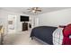 Carpeted bedroom with a ceiling fan, TV on the stand, and a bathroom with a shower at 12 Hemlock Radial Pass, Ocala, FL 34472