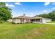 Charming single-story home with a manicured lawn, mature trees, and a welcoming screened front porch at 12 Hemlock Radial Pass, Ocala, FL 34472