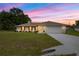 Well-maintained house with a two-car garage, a manicured front lawn, and an inviting entryway at twilight at 12 Hemlock Radial Pass, Ocala, FL 34472