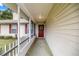 Charming covered front porch with a decorative wreath on a red front door, offering curb appeal and a welcoming entrance at 12 Hemlock Radial Pass, Ocala, FL 34472