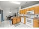 Practical kitchen with white appliances, plenty of cabinet space, and a view of the dining area for easy access at 12 Hemlock Radial Pass, Ocala, FL 34472