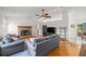 Bright living room featuring a brick fireplace, hardwood floors, and a vaulted ceiling with modern furniture at 12 Hemlock Radial Pass, Ocala, FL 34472