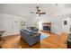 Spacious living room with hardwood floors, featuring a brick fireplace, and a ceiling fan for added comfort at 12 Hemlock Radial Pass, Ocala, FL 34472