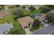 Aerial view showcases a home with lush landscaping, mature trees, and well-kept lawn at 13715 Se 88Th Ct, Summerfield, FL 34491