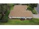 This aerial view highlights the home's tidy landscaping and back patio at 13715 Se 88Th Ct, Summerfield, FL 34491