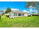 Back of the home with a screened in porch and beautiful lawn with mature trees, perfect for entertaining at 13715 Se 88Th Ct, Summerfield, FL 34491