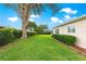 Home with a beautiful backyard featuring a tree with mature greenery and manicured landscaping at 13715 Se 88Th Ct, Summerfield, FL 34491