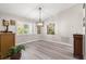 Bright dining room with plantation shutters, gray flooring, and decorative lighting at 13715 Se 88Th Ct, Summerfield, FL 34491
