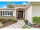 Inviting front entrance with a well-maintained walkway and beautifully landscaped garden at 13715 Se 88Th Ct, Summerfield, FL 34491