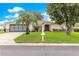 Charming home featuring a well-manicured lawn and a classic exterior design with mature trees at 13715 Se 88Th Ct, Summerfield, FL 34491
