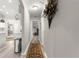 Long hallway with neutral walls, wood floors and connecting to living space at 13715 Se 88Th Ct, Summerfield, FL 34491