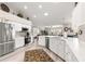 Modern kitchen with stainless steel appliances, white cabinetry, and a bright, open layout at 13715 Se 88Th Ct, Summerfield, FL 34491