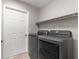 Efficient laundry room featuring newer front load washer and dryer with shelving at 13715 Se 88Th Ct, Summerfield, FL 34491
