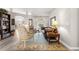 Living room with a patterned rug, leather sofa, chair, and bookcase at 13715 Se 88Th Ct, Summerfield, FL 34491